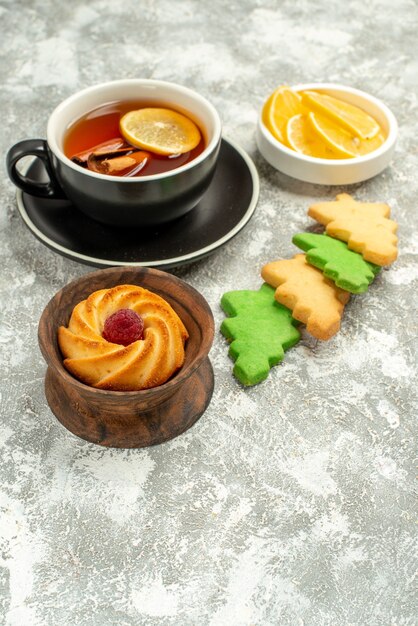 Vista inferior de la taza de té de las galletas del árbol de Navidad en una superficie gris con espacio de copia