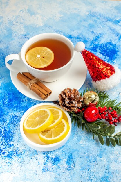 Vista inferior taza de té rodajas de limón gorro de Papá Noel en el cuadro azul