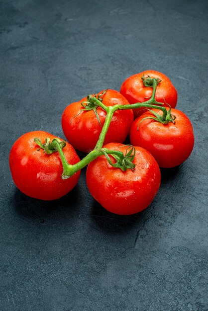 Vista inferior de tomates frescos en el espacio libre de la mesa oscura