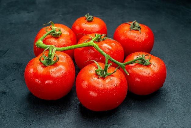 Vista inferior de tomates rojos frescos en la mesa oscura