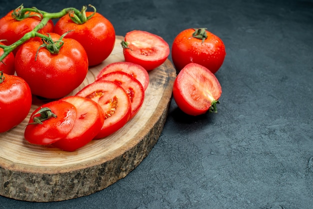 Vista inferior tomates rojos frescos tomates picados sobre tablero de madera en el espacio libre de la mesa negra