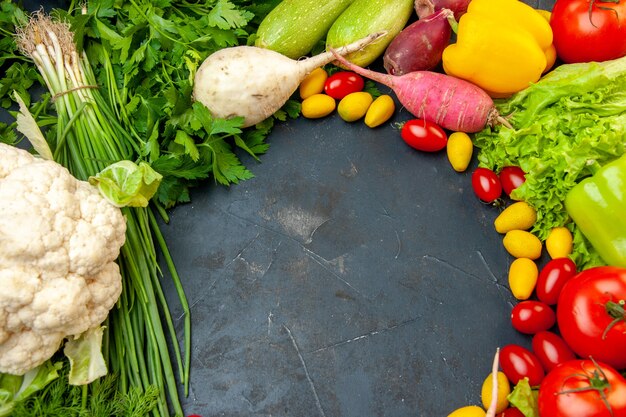 Vista inferior verduras frescas tomates cherry cumcuat coliflor rábano cebolla verde perejil tomates pimientos espacio libre