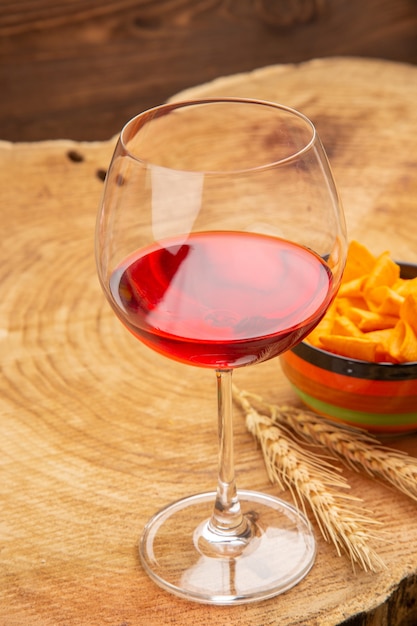 Vista inferior del vino en la copa de vino del globo chips en un recipiente sobre la superficie de madera