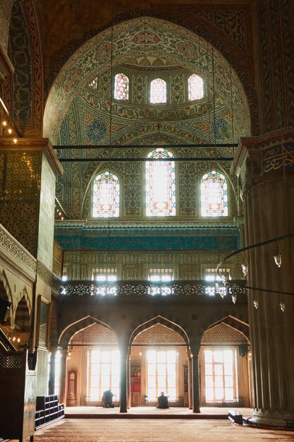 Vista interior de la mezquita azul grandes columnas arcos y paredes con adorno