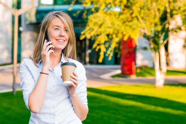 Vista de una joven atractiva mujer de negocios utilizando teléfono inteligente