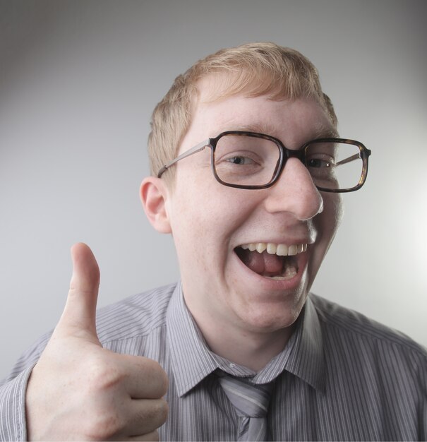 Vista de un joven varón caucásico vistiendo una camisa y corbata con impresiones de cara feliz - concepto: feliz