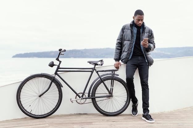 Vista larga del hombre con su bicicleta