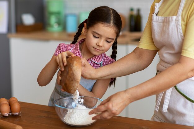 Vista lateral abuela y niña cocinando juntas