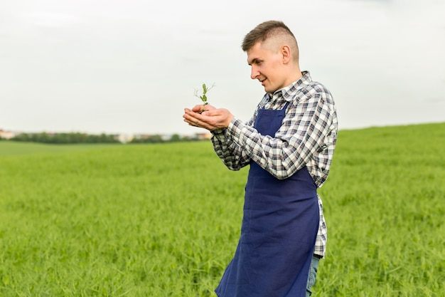 Vista lateral agricultor con planta