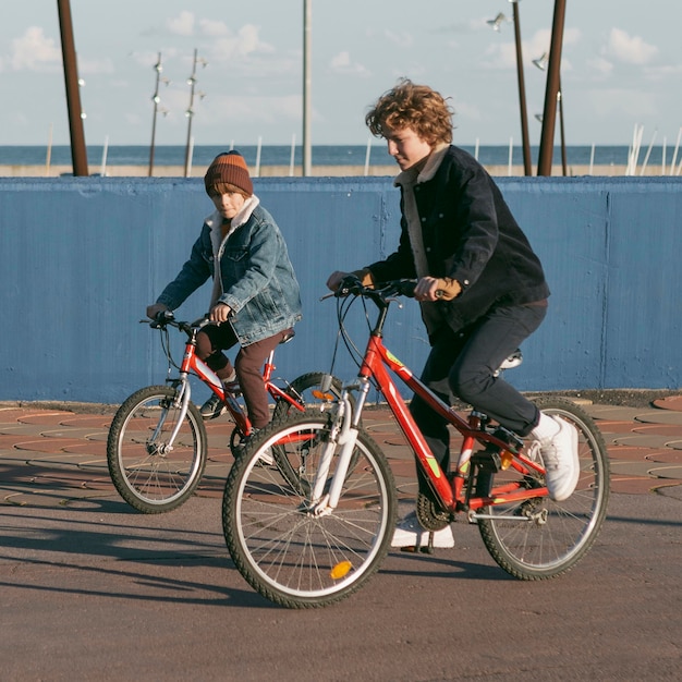 Vista lateral de los amigos del niño al aire libre en bicicletas