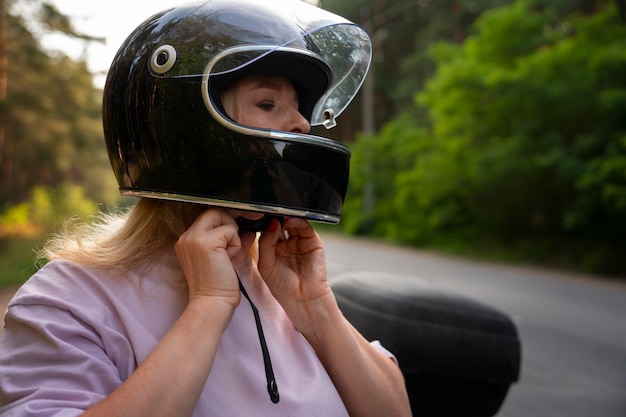 Foto gratuita vista lateral de una anciana con motocicleta