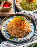 Foto gratuita vista lateral del arroz japonés frito con verduras en salsa de soja en un plato sobre madera