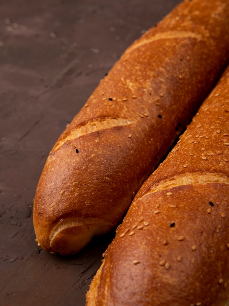 Vista lateral de baguettes sobre fondo marrón con espacio de copia