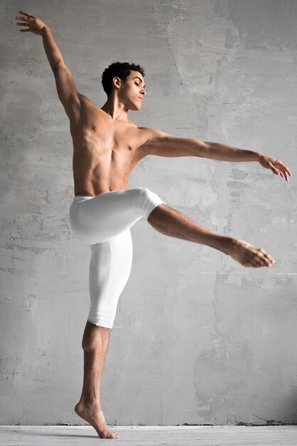 Vista lateral del bailarín de ballet masculino sin camisa