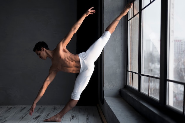 Vista lateral del bailarín de ballet masculino en medias