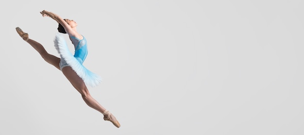 Vista lateral de la bailarina en el aire con espacio de copia