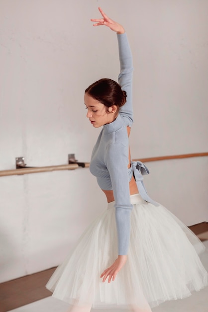 Vista lateral de la bailarina bailando en falda de tutú