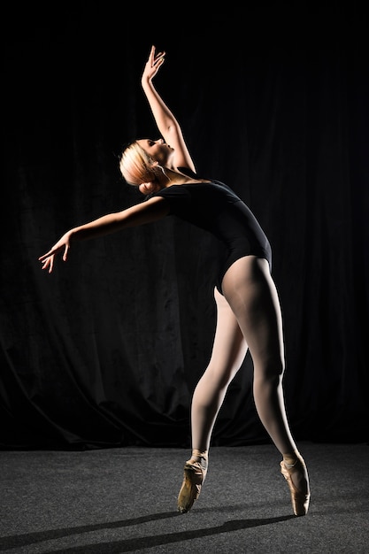 Vista lateral de la bailarina de ballet en leotardo