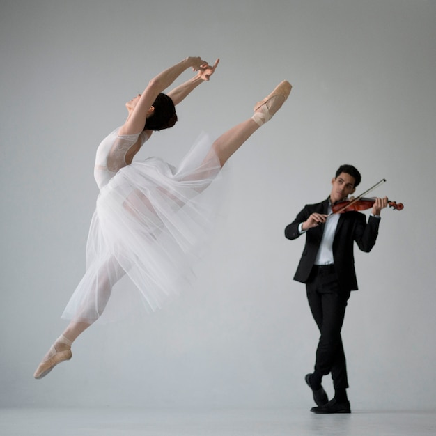 Vista lateral de la bailarina con músico de violín