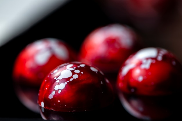 Vista lateral del caramelo de chocolate con motas rojas a blancas