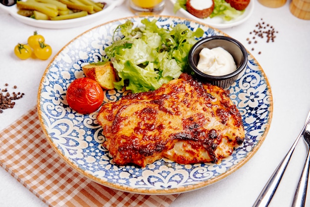 Foto gratuita vista lateral de carne de pollo al horno con queso tomate a la parrilla y papas