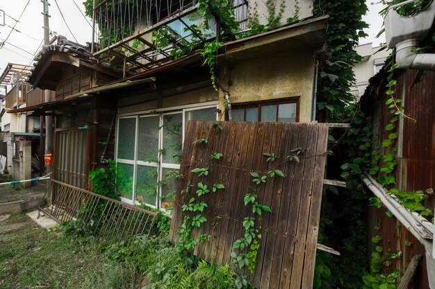 Vista lateral casa abandonada con plantas.