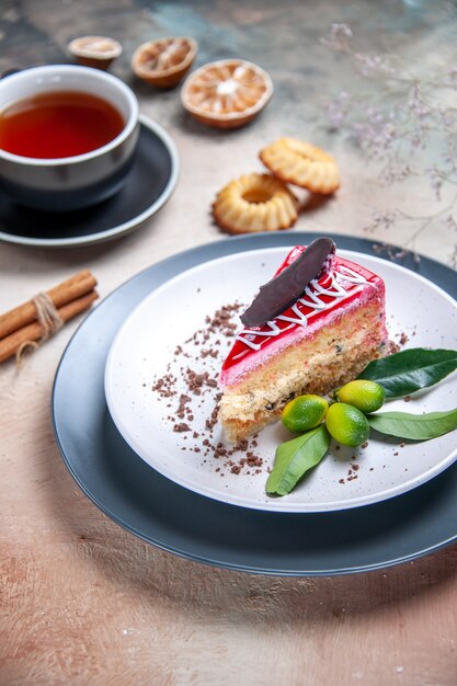 Vista lateral de cerca un pastel un pastel con frutas cítricas de chocolate una taza de té galletas canela