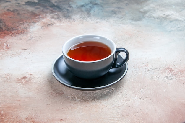 Vista lateral de cerca una taza de té negro taza de té sobre la mesa