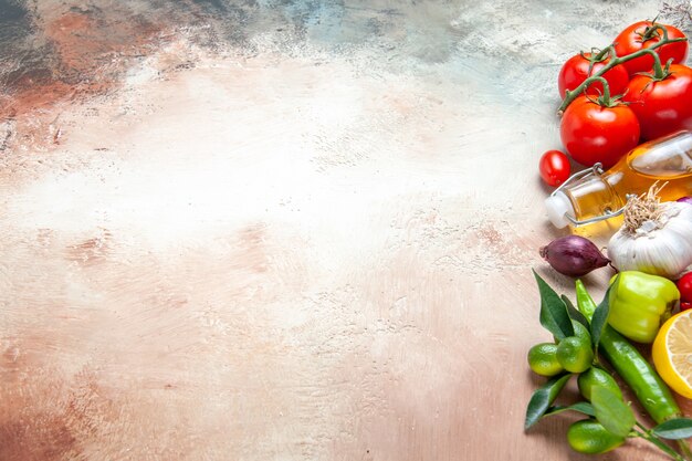 Vista lateral de cerca verduras aceite de limón cebolla ajo pimientos tomates con pedicelos