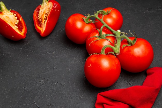 Vista lateral de cerca verduras pimientos rojos tomates con mantel pedicelos