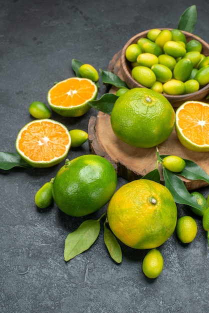 Vista lateral cercana da frutos al tablero con los apetitosos frutos cítricos con hojas