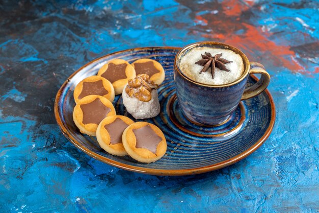 Vista lateral cercana dulces galletas delicias turcas y una taza de café en la placa azul