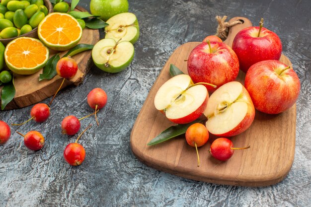 Vista lateral cercana frutas bayas cítricos manzanas rojas en el tablero