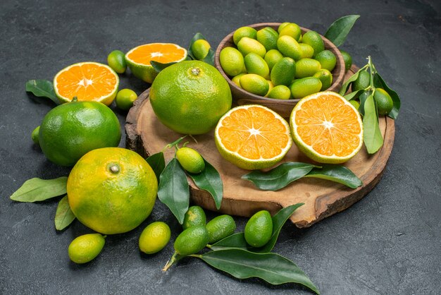 Vista lateral cercana frutas mandarinas cítricos con hojas en el tablero