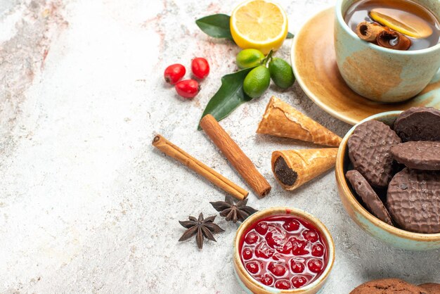 Vista lateral cercana galletas y té galletas de chocolate una taza de té mermelada de cítricos canela