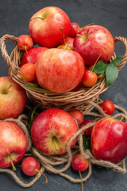 Vista lateral cercana manzanas manzanas las apetitosas cerezas en la canasta