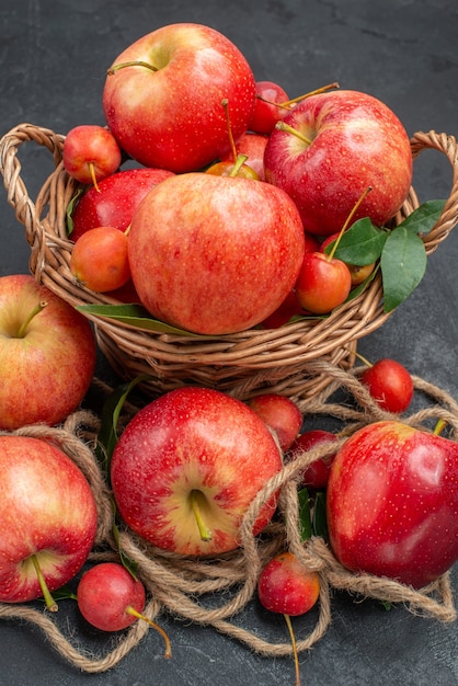 Vista lateral cercana manzanas manzanas las apetitosas cerezas en la canasta