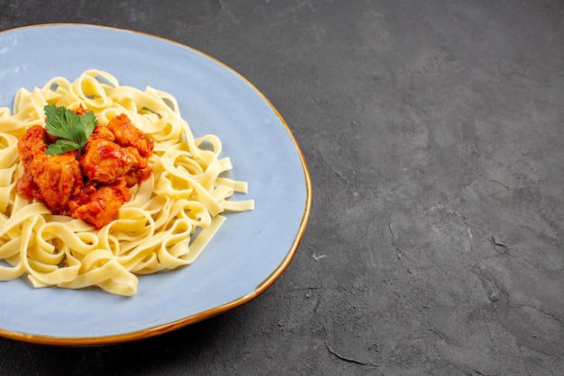 Vista lateral cercana pasta con carne en el lado izquierdo de la mesa pasta con carne y salsa