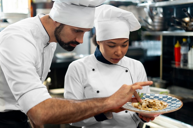 Foto gratuita vista lateral de chefs profesionales trabajando juntos