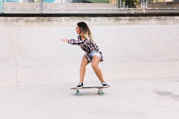 Vista lateral de chica skater en tabla