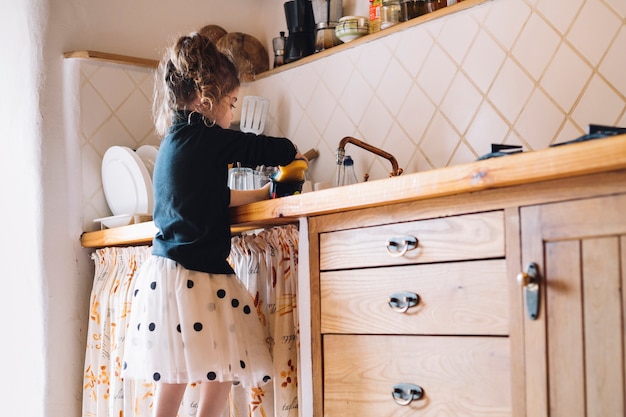 Foto gratuita vista lateral de una chica taza de lavado en la cocina