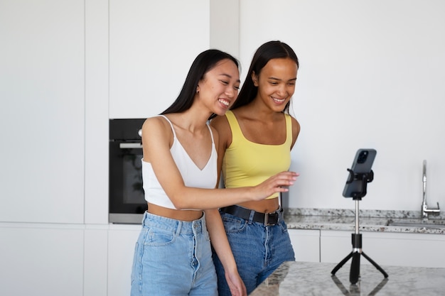 Foto gratuita vista lateral de chicas sonrientes con teléfono inteligente