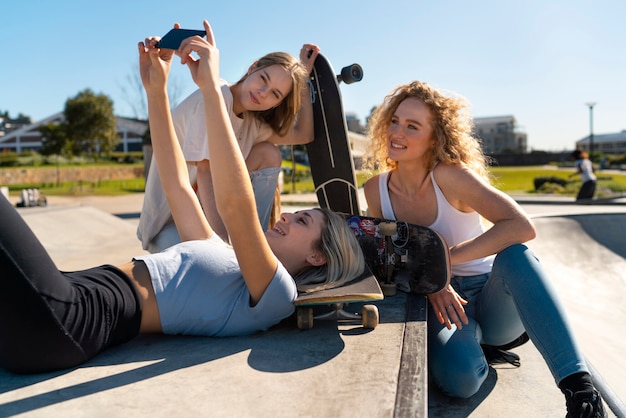 Vista lateral de chicas sonrientes tomando selfie