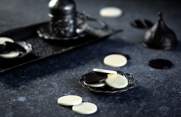 Vista lateral del círculo de dulces de chocolate en una mesa negra jpg