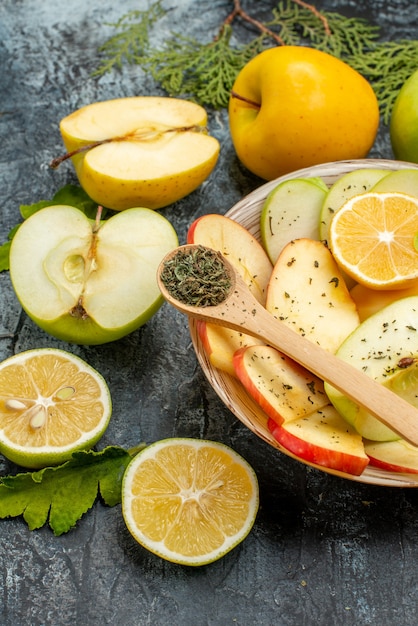 Vista lateral de la colección de frutas orgánicas naturales frescas en una placa blanca ramas de abeto sobre un fondo oscuro