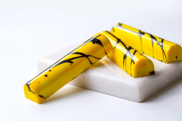 Vista lateral de color amarillo en negro moteado de caramelo de chocolate en soporte blanco