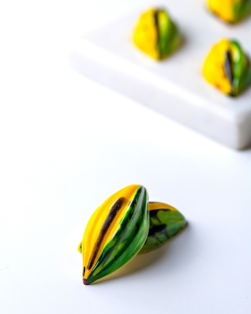 Vista lateral de color verde amarillo en negro moteado de caramelo de chocolate en soporte blanco