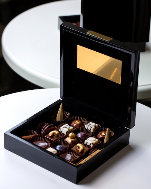 Vista lateral decorada con bombones de chocolate en una caja de oro negro