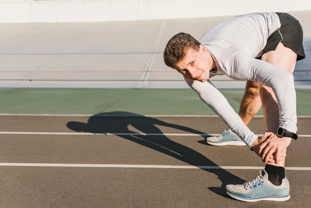 Foto gratuita vista lateral de deporte hombre haciendo estiramientos