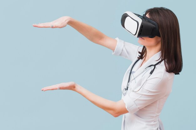 Vista lateral de la doctora con casco de realidad virtual